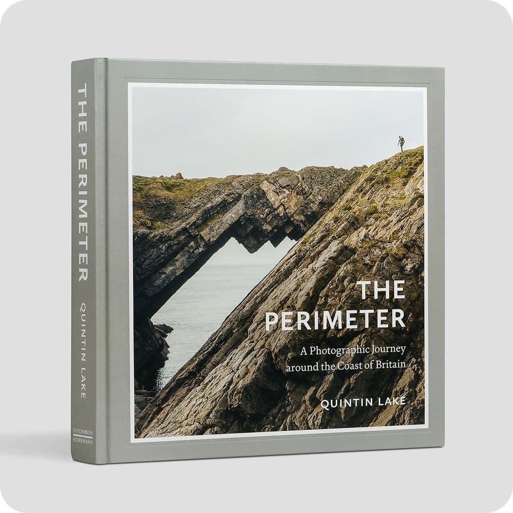 Book cover titled "The Perimeter" by Quintin Lake, featuring a rugged coastal rock formation with a person standing on top.