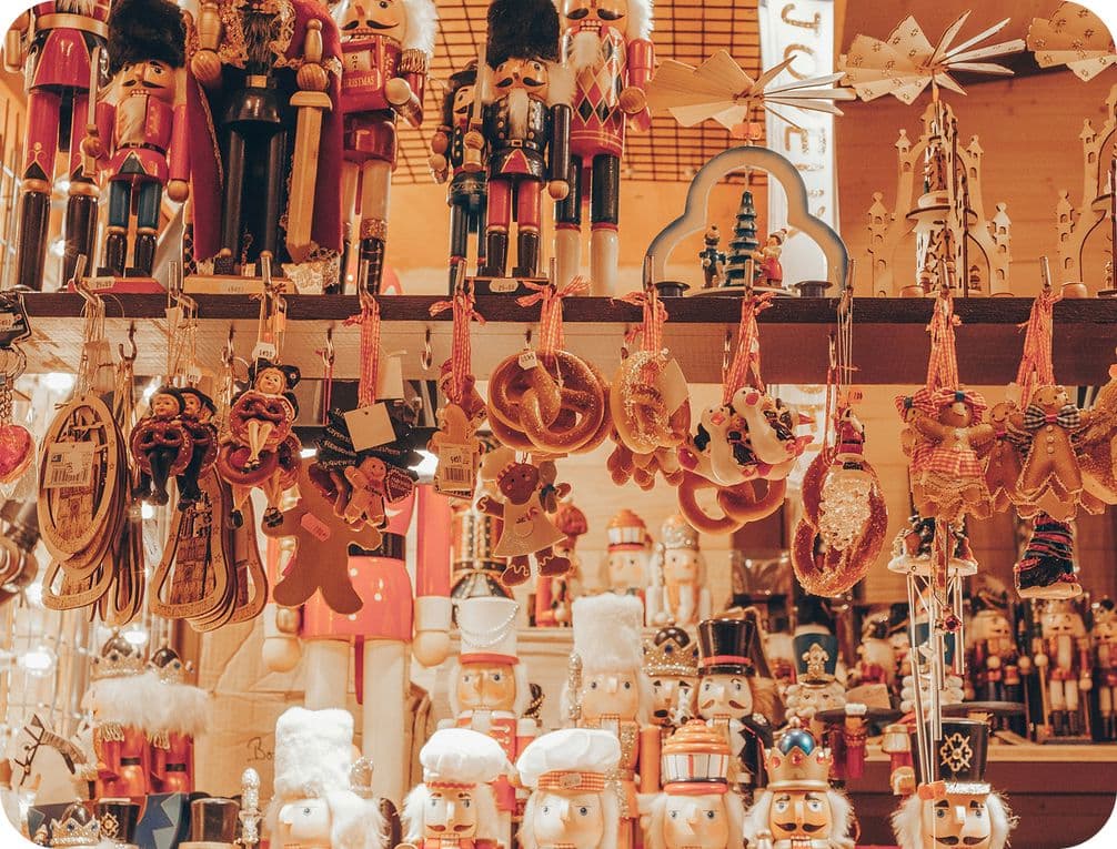A festive market stall displaying various nutcrackers and hanging Christmas ornaments, including gingerbread figures and stars.