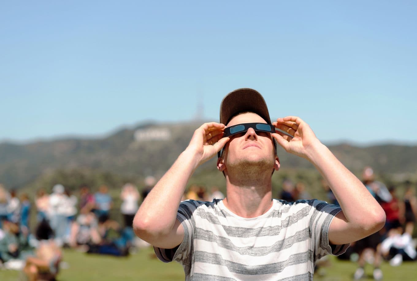 A man wearing protective glasses observing a solar eclipse