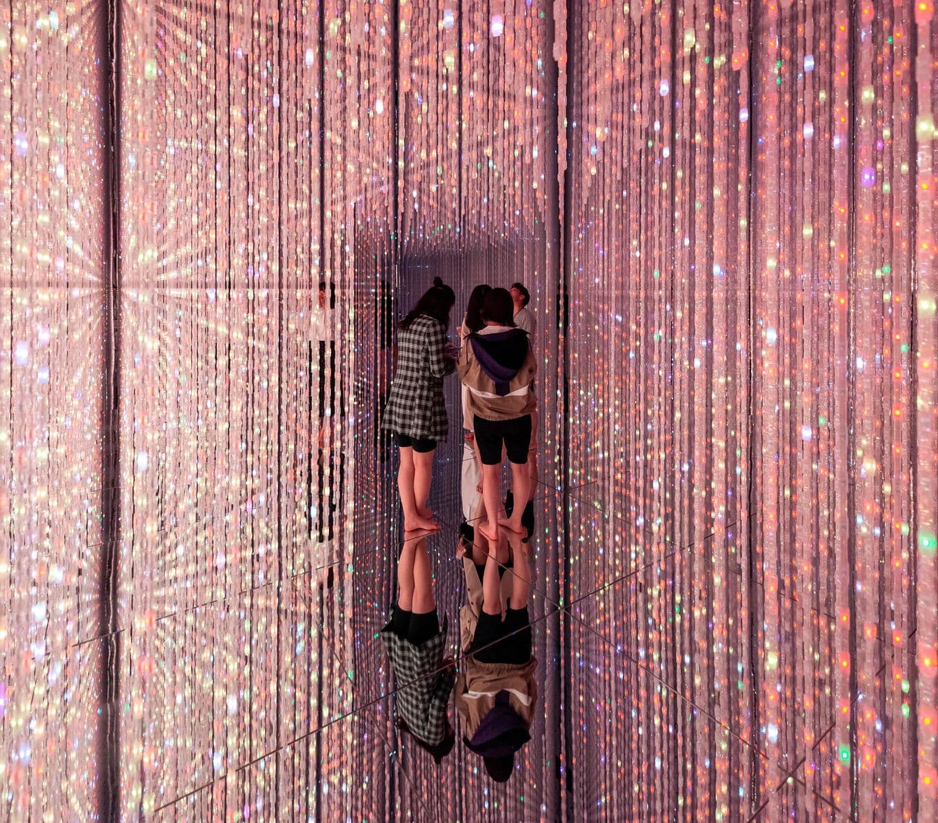 Friends standing barefoot inside teamLab Planets, Tokyo, Japan