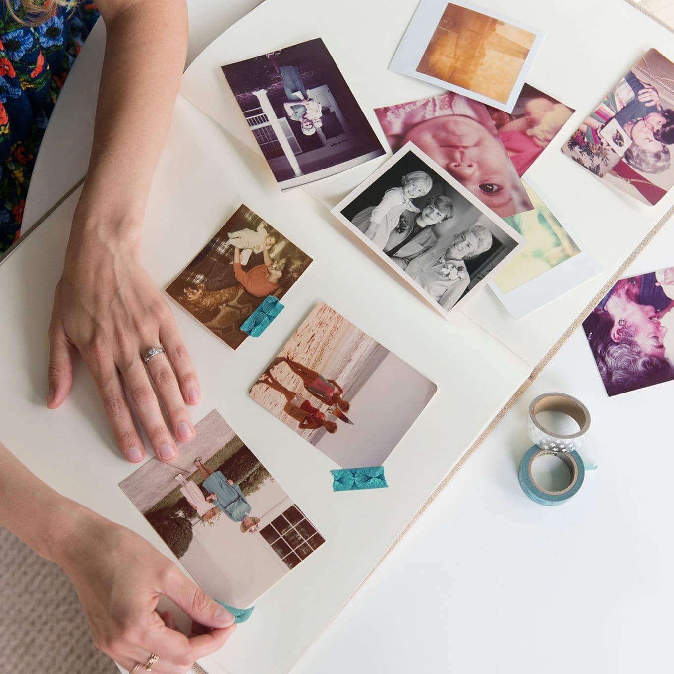 A mother arranges old family photos in a photo album