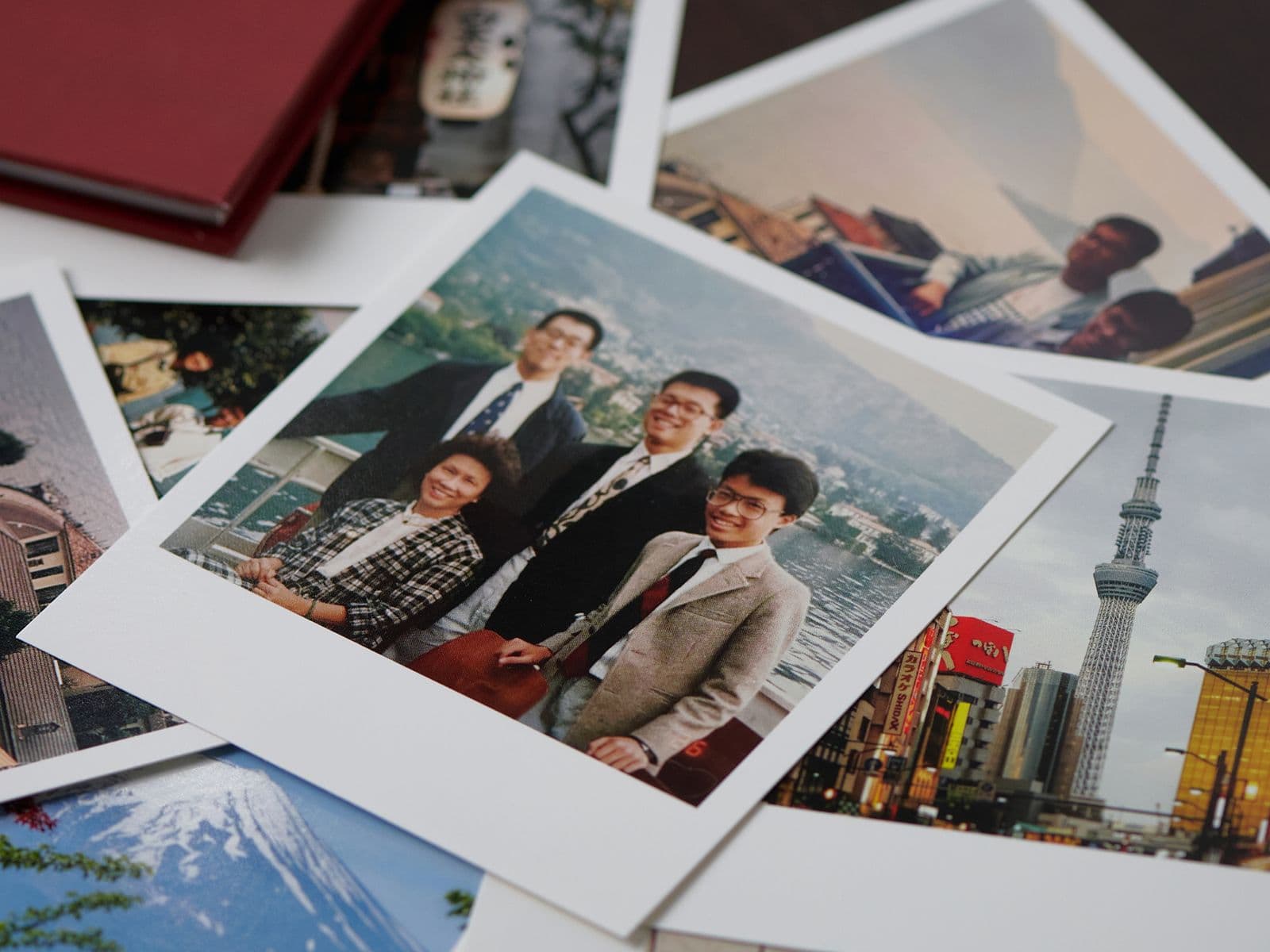 A collection of scattered photographs, including a group portrait and scenic views of a city skyline and a mountain.