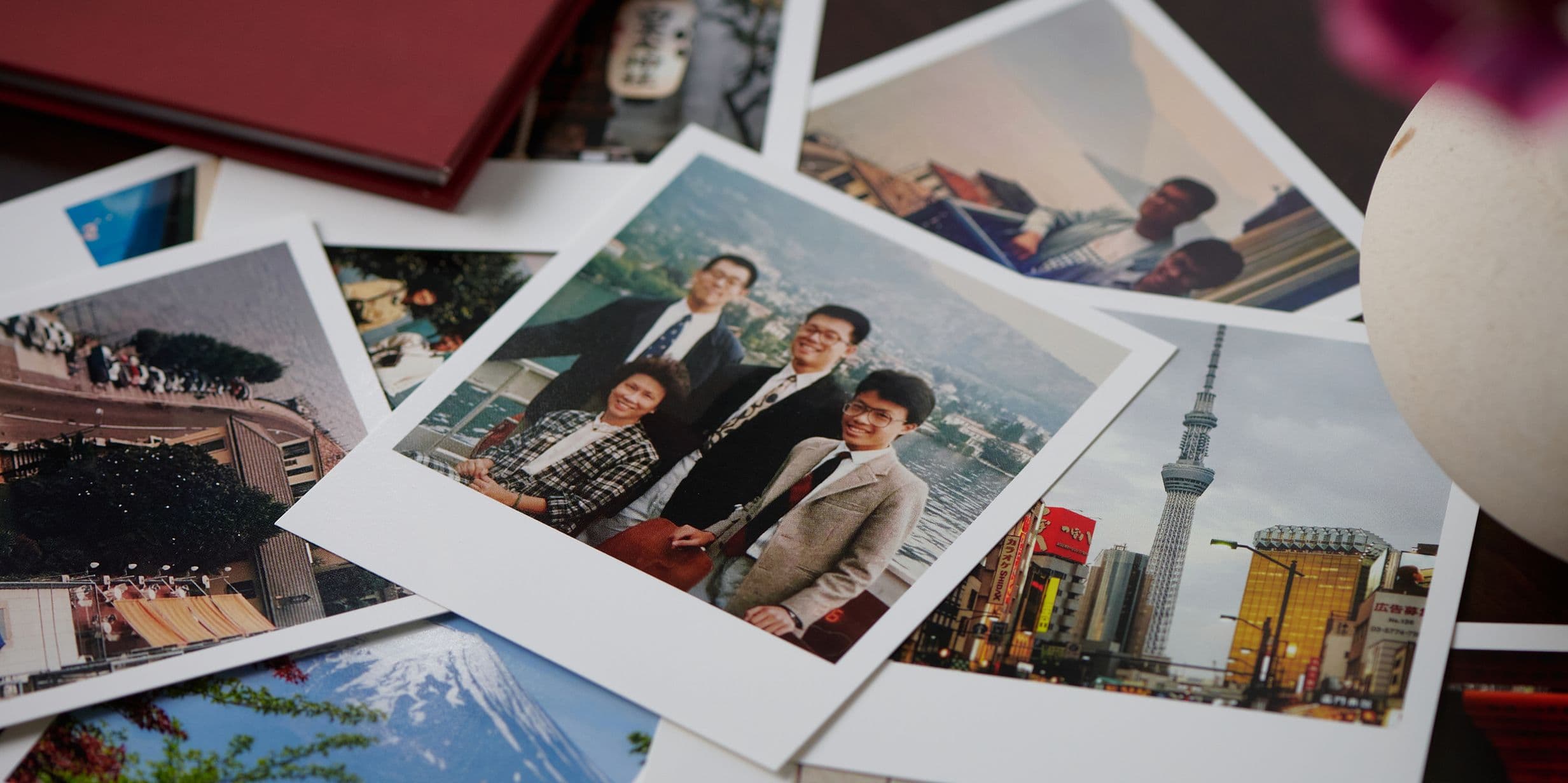 A collection of scattered photographs, including a group portrait and scenic views of a city skyline and a mountain.