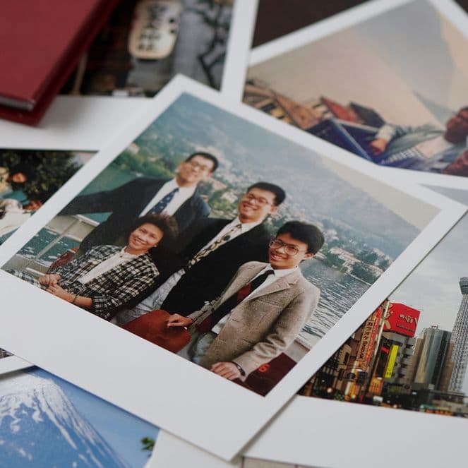 A collection of scattered photographs, including a group portrait and scenic views of a city skyline and a mountain.