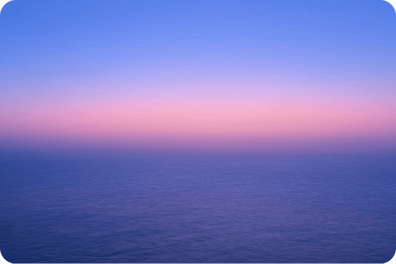 A serene ocean view at sunset with a gradient sky transitioning from pink to blue, reflecting on the calm water.