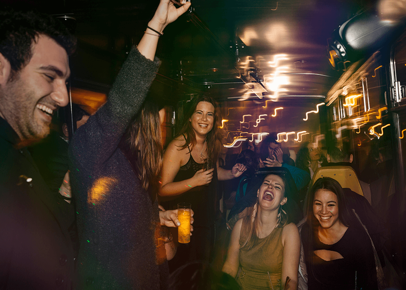 A lively group of people laughing and celebrating on a party bus.