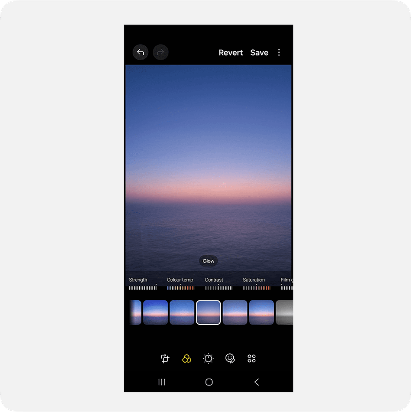 Smartphone screen displaying a photo editing app with a sunset image, showing various adjustment options like filters, contrast, and saturation.