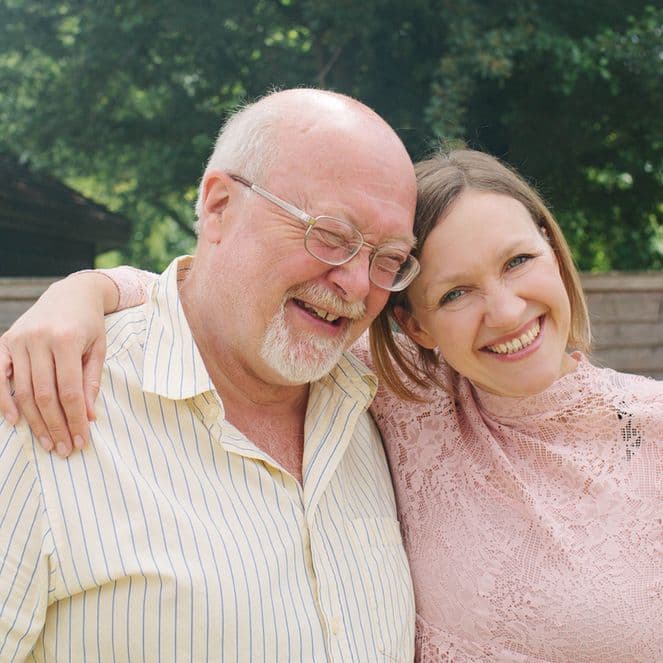 Father and daughter cuddling at outdoor birthday party