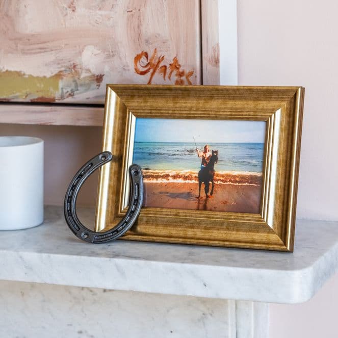 A framed photo of a young Staci Layne Wilson riding her pony, Smokey, on the beach