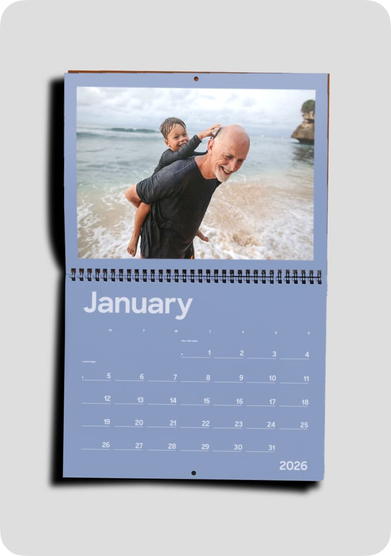 Calendar page for January 2026 featuring a man giving a child a piggyback ride on a beach, with waves in the background.